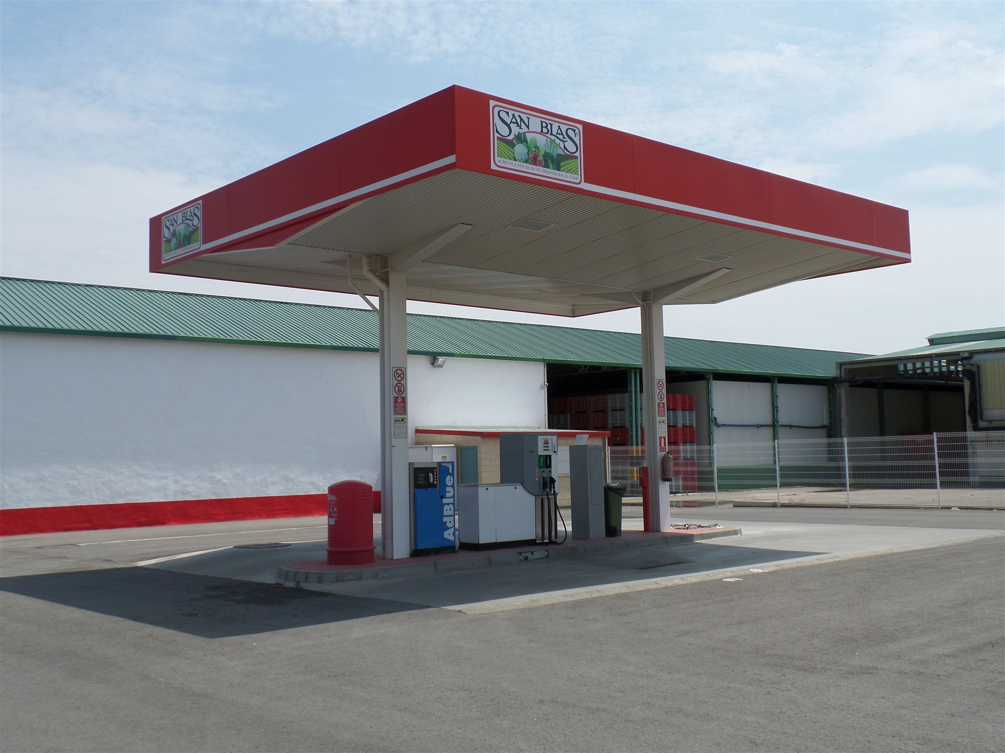 Una gasolinera con un surtidor y una marquesina
